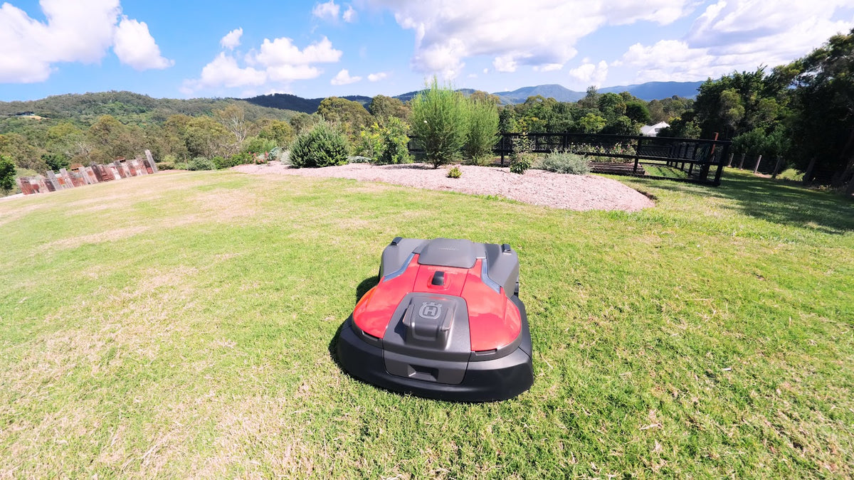 Automower 580 EPOS on sloped lawn with mountain view